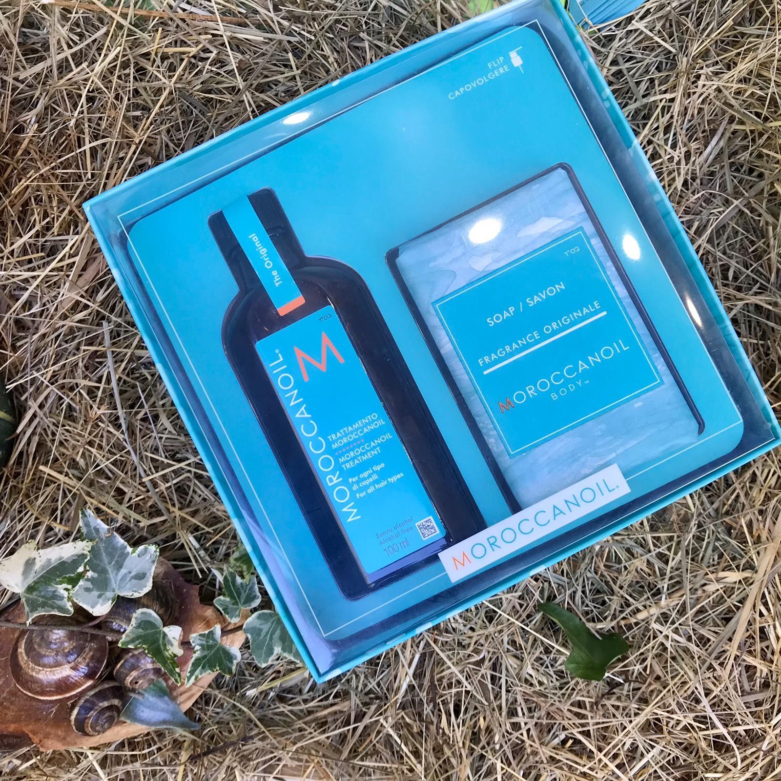 Set regalo per la cura della pelle Blue in una scatola su un prato, comprendente una bottiglia e un flacone con dosatore.