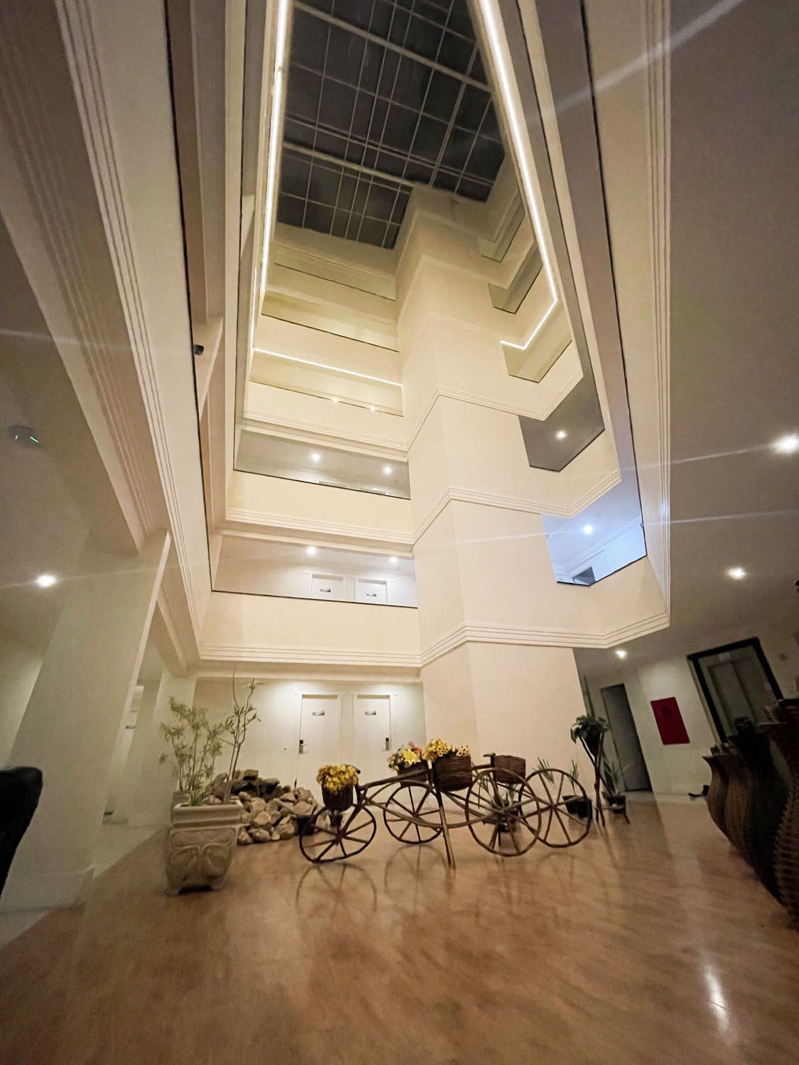 Um grande lobby de um hotel com uma carruagem no meio.