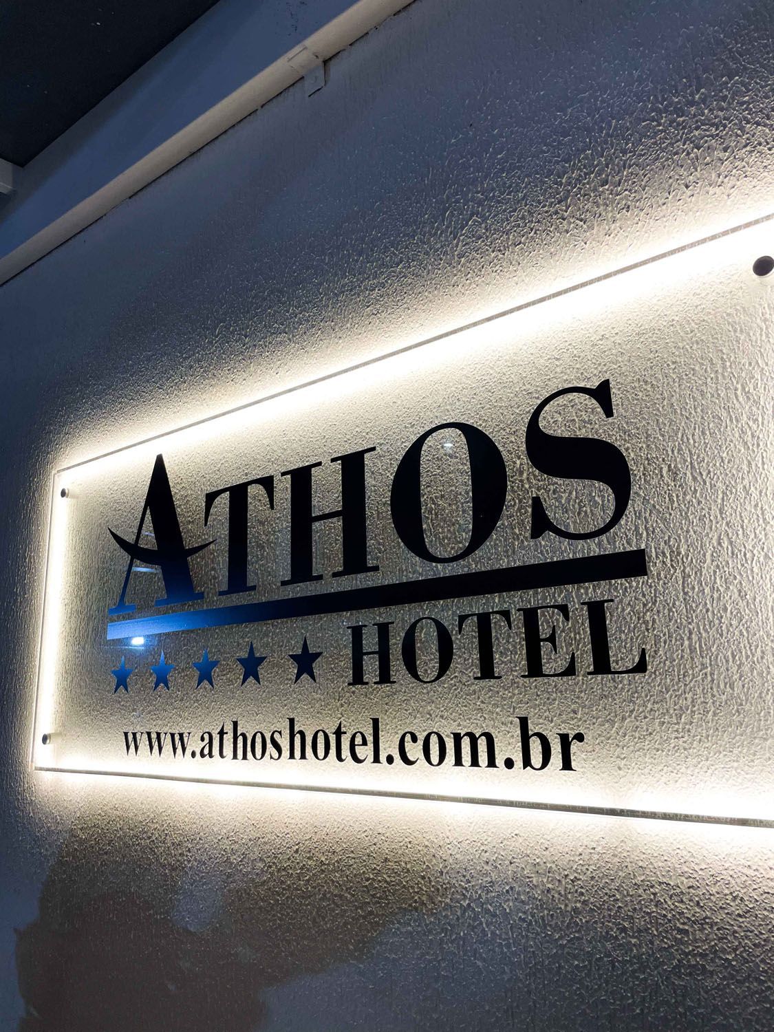 Um grande edifício com muitas janelas fica iluminado à noite.