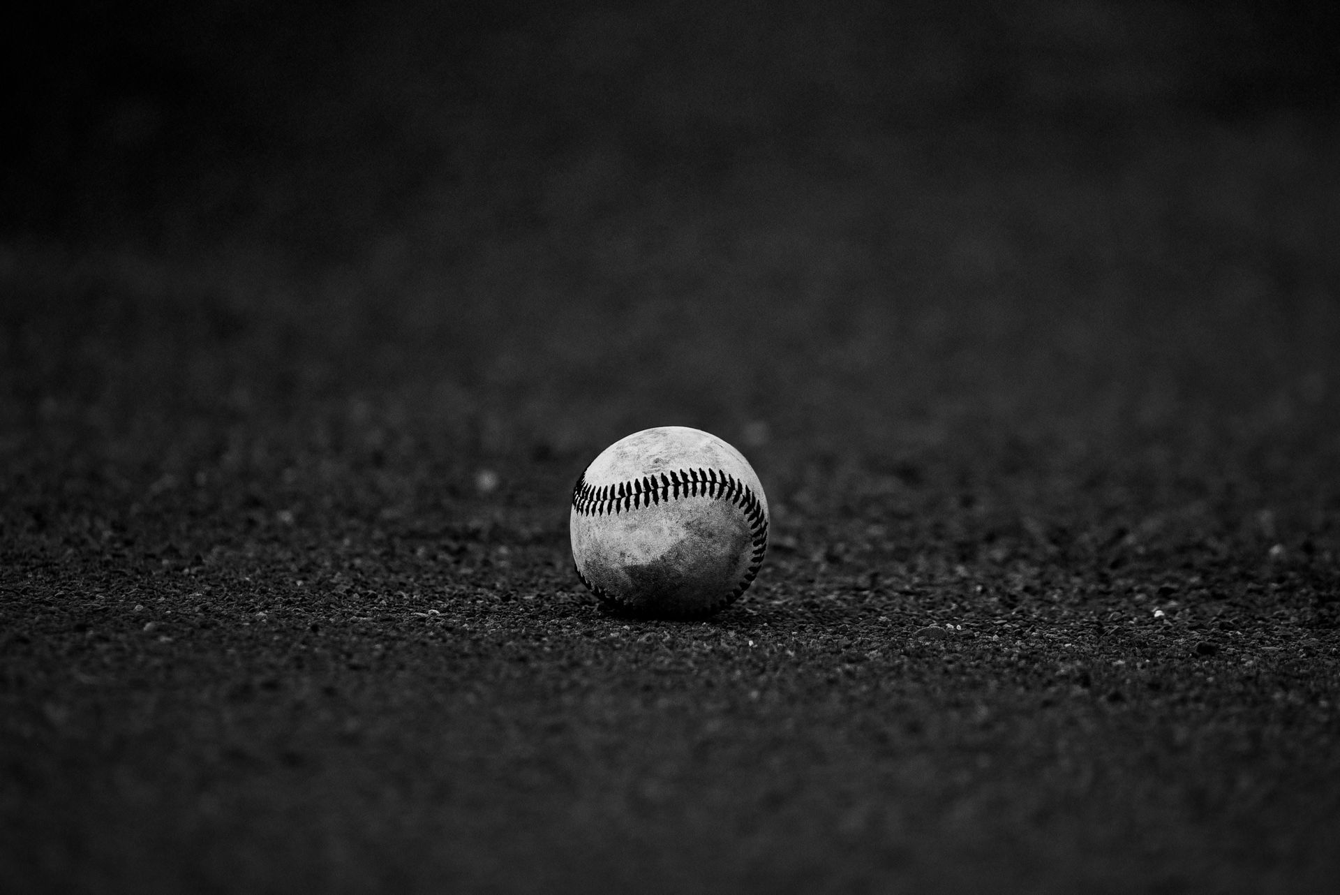 Baseball on a dark surface, with visible stitching.