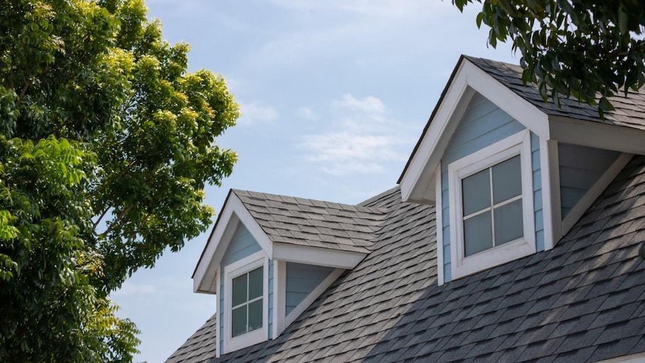 A house with a roof that has two windows on it