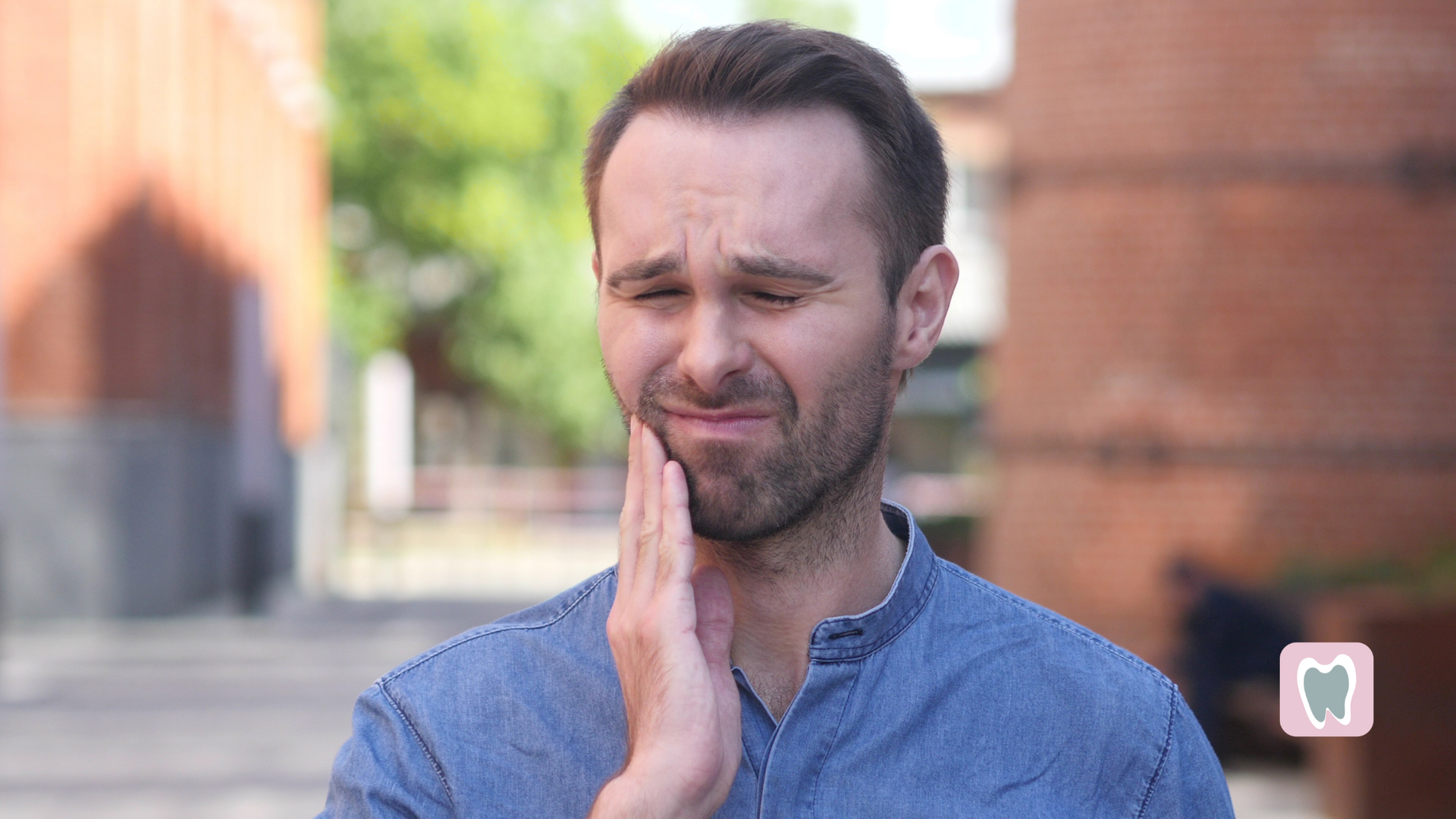 A man is holding his face in pain because of a toothache.
