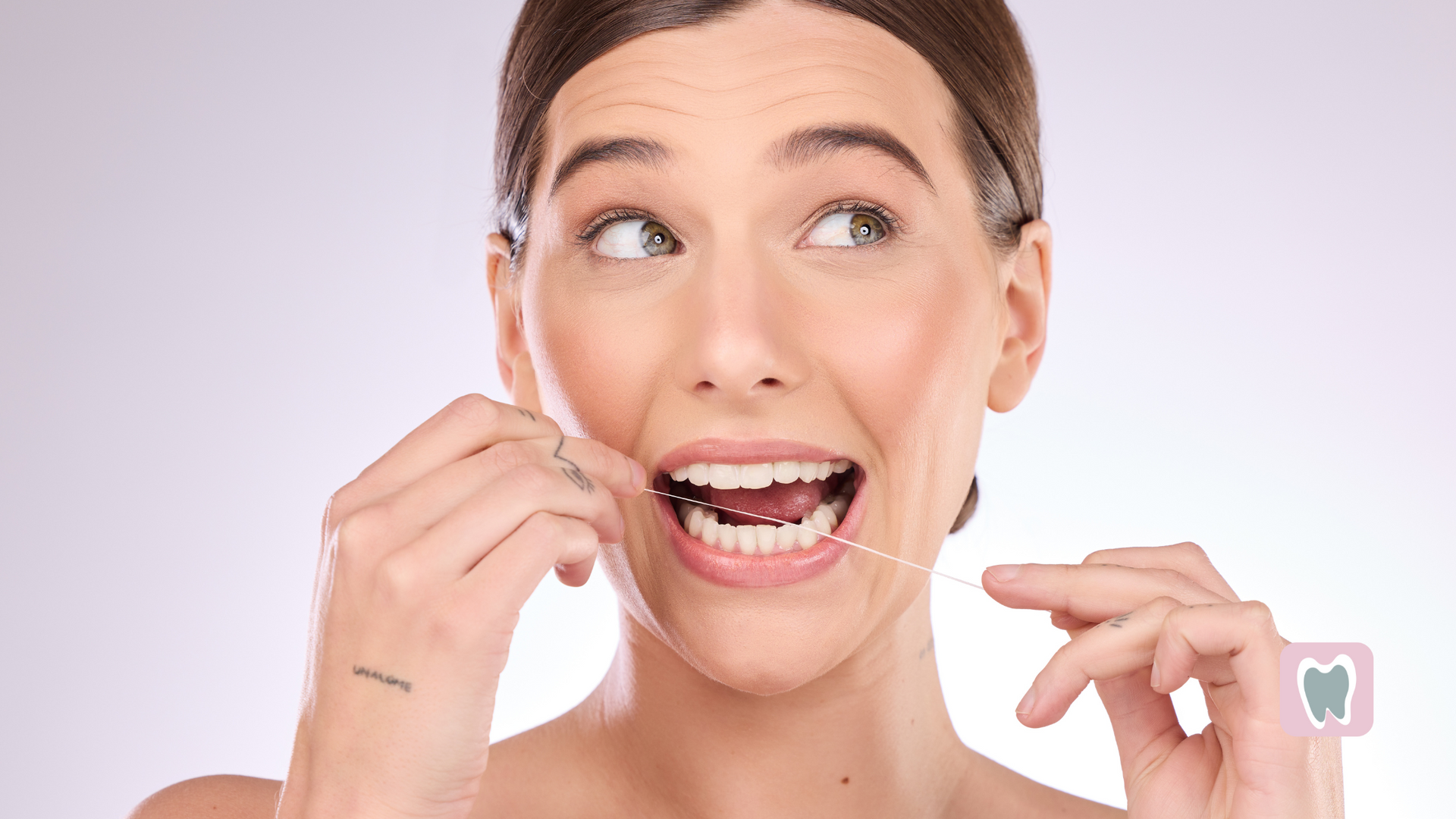 A woman is flossing her teeth with a dental floss.