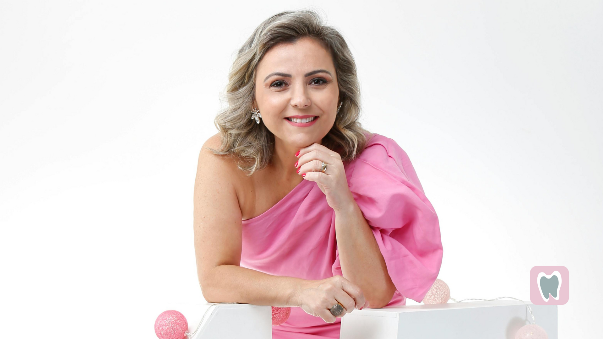 A woman in a pink dress is sitting at a table.