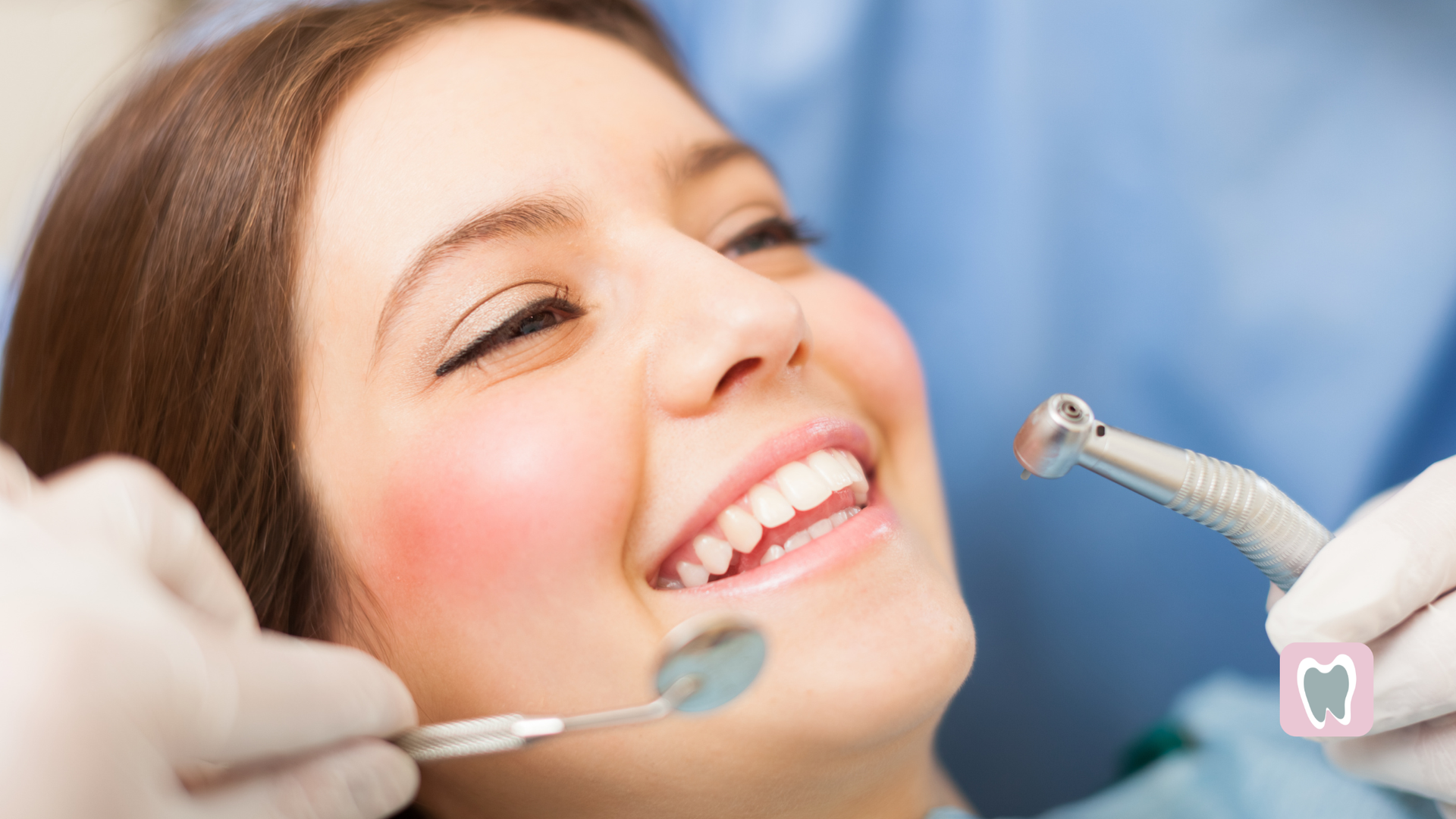 Woman smiling at dentist, receiving dental work with tools in mouth.