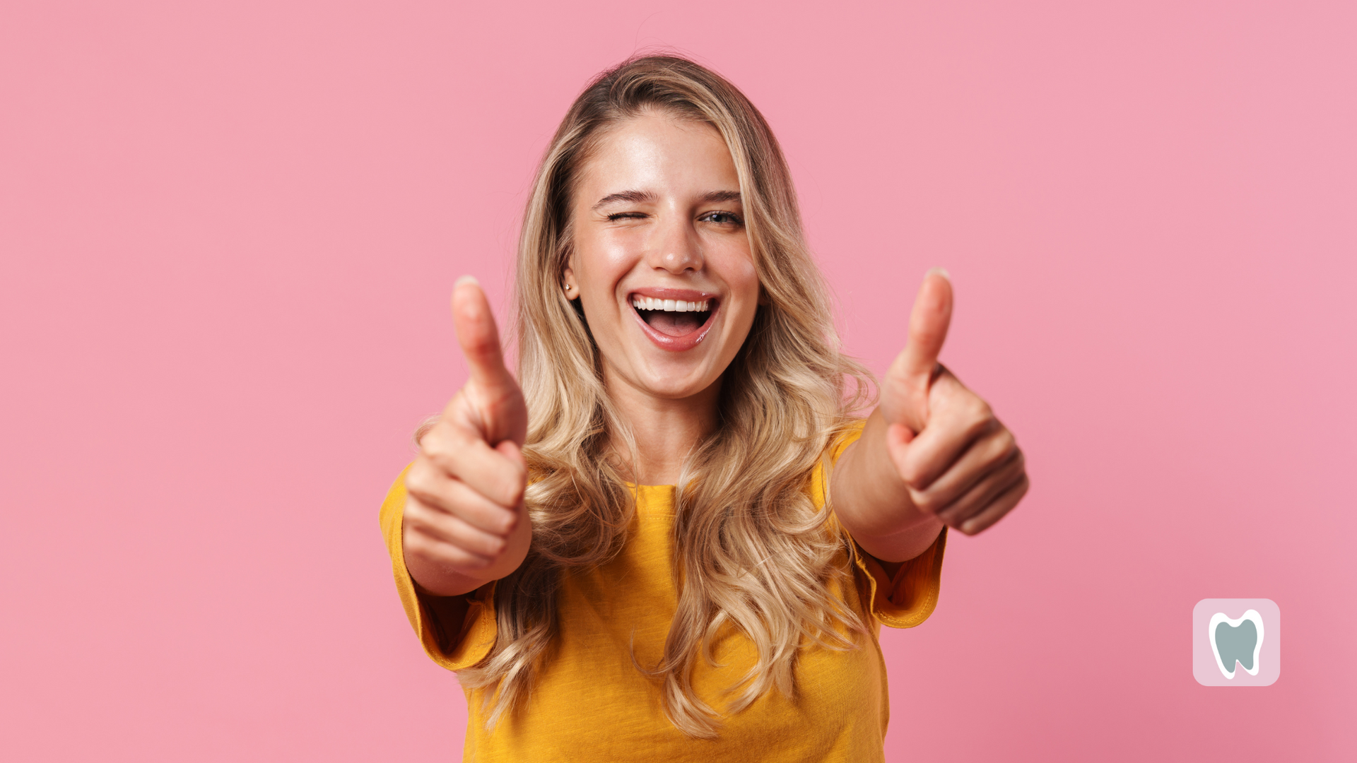 A woman is giving two thumbs up on a pink background.