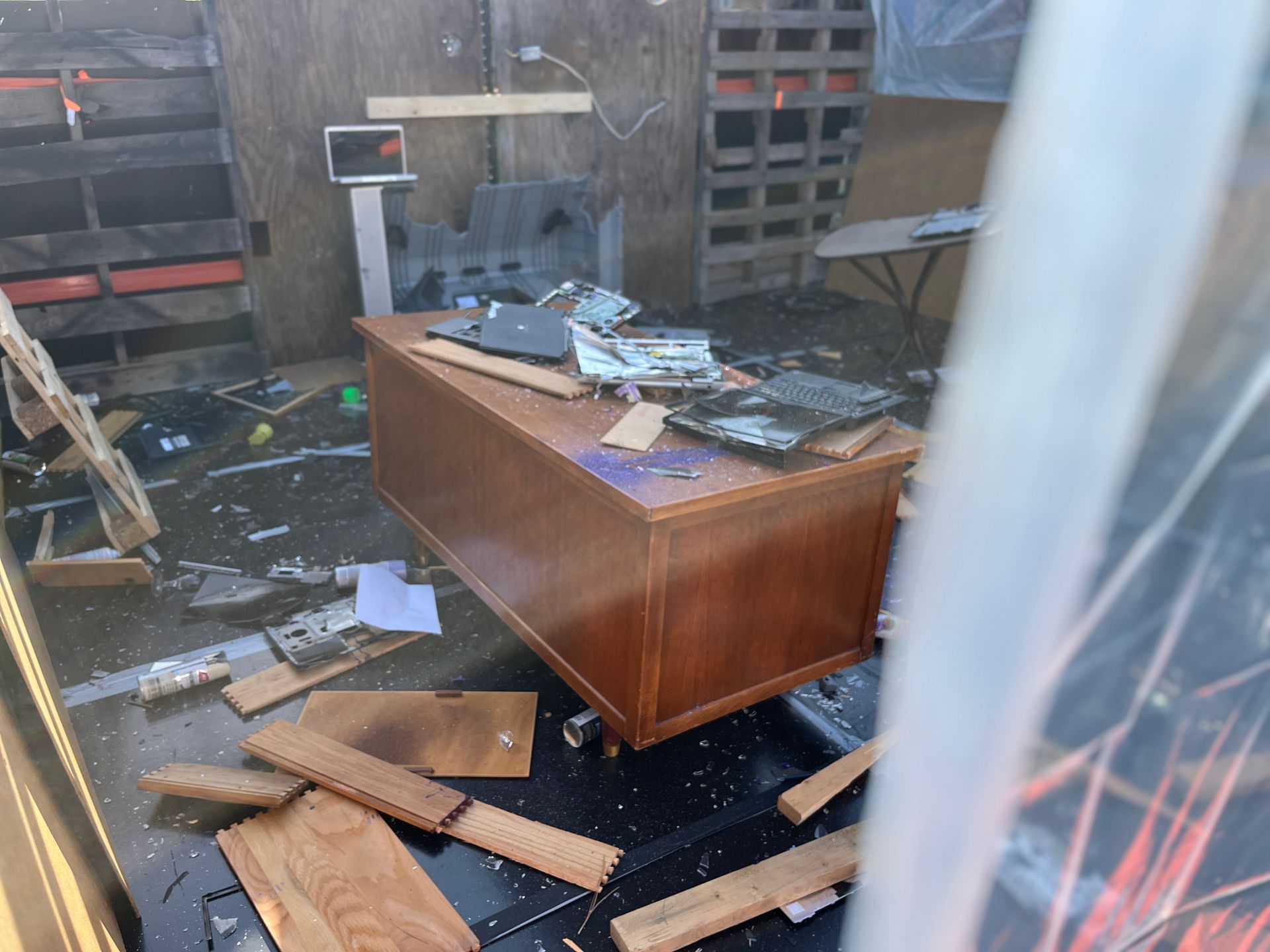 A messy room with a desk in the middle of it