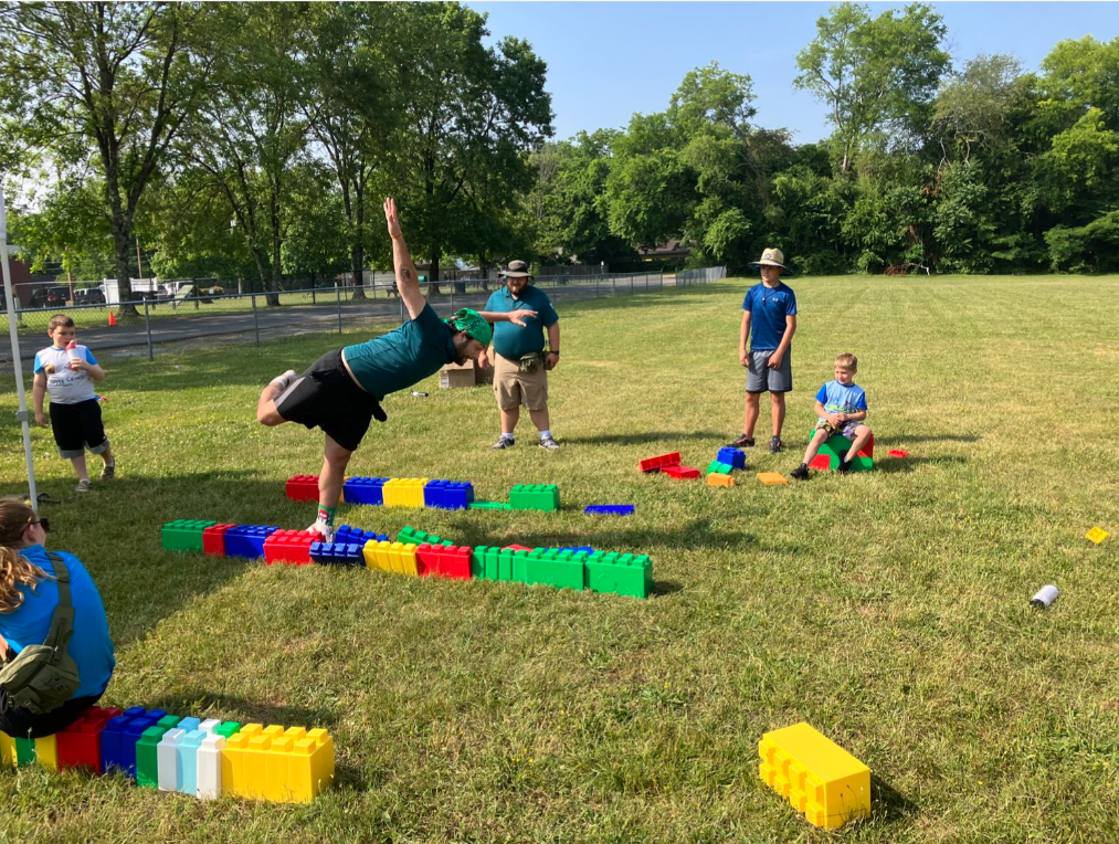 A group of people are playing with blocks in a field.