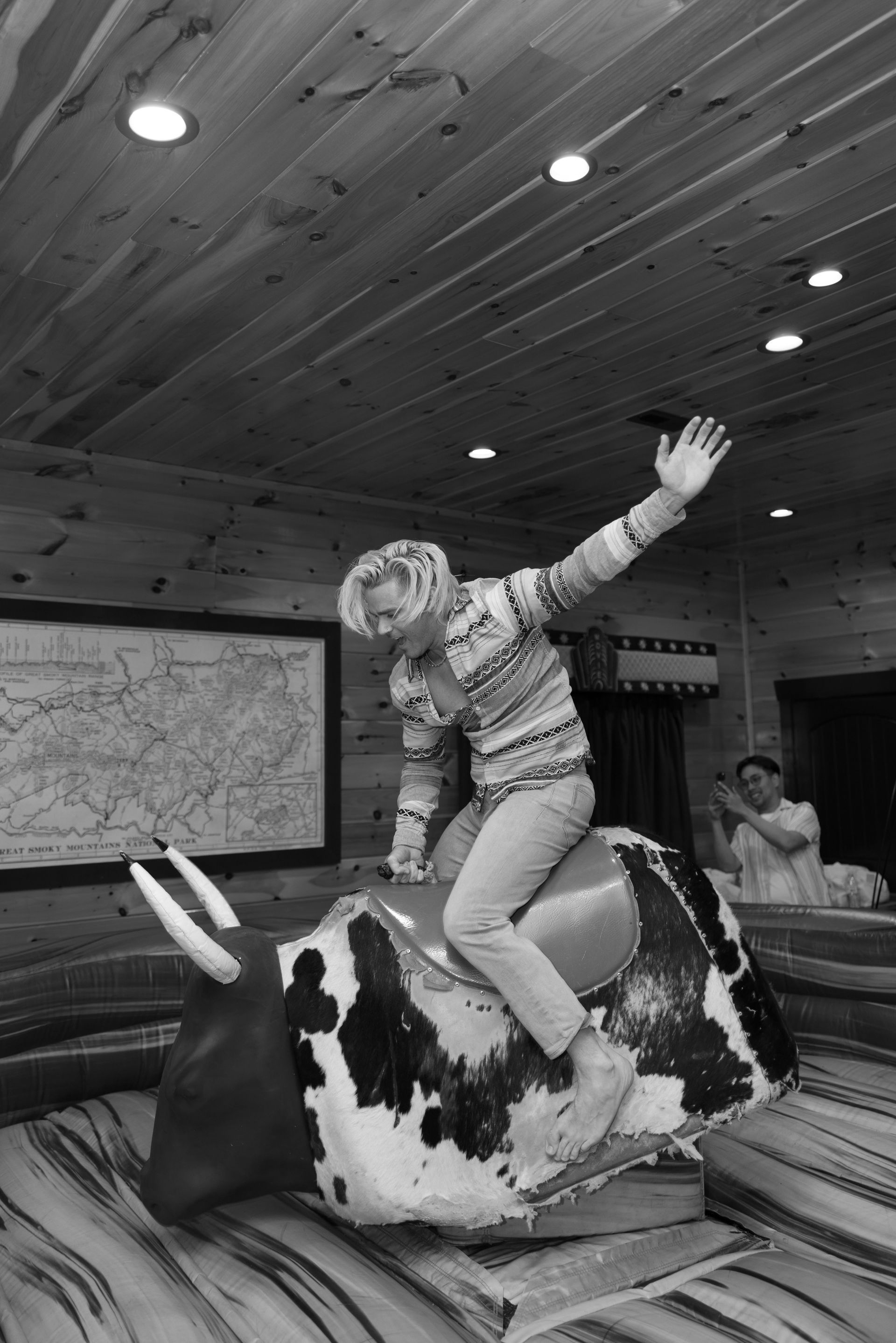 A person is riding a bull in a black and white photo.