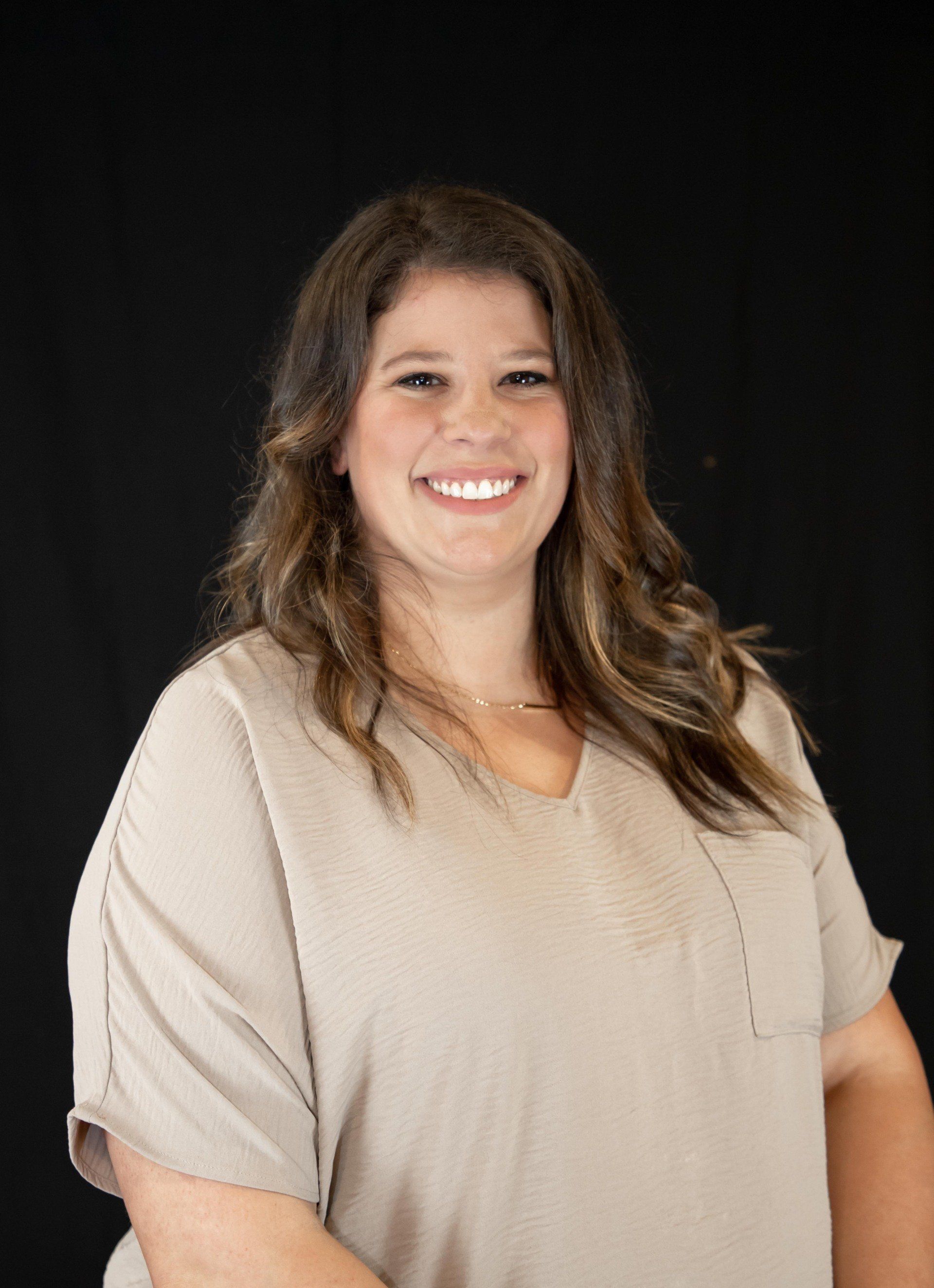 Headshot of Lauren in front of black background