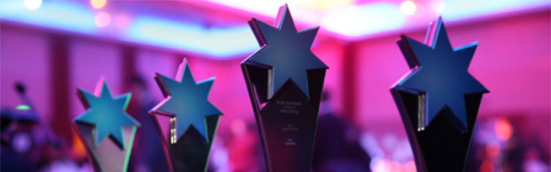 A group of NESA Award trophies with stars on them are sitting in a room.