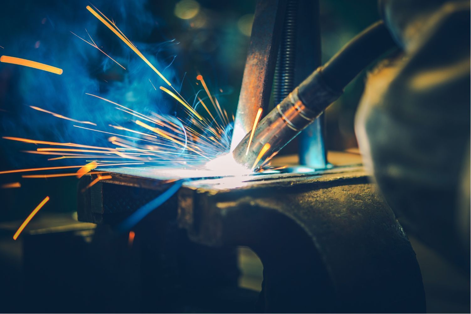 Close-up of welding sparks flying from metal in a dark workshop