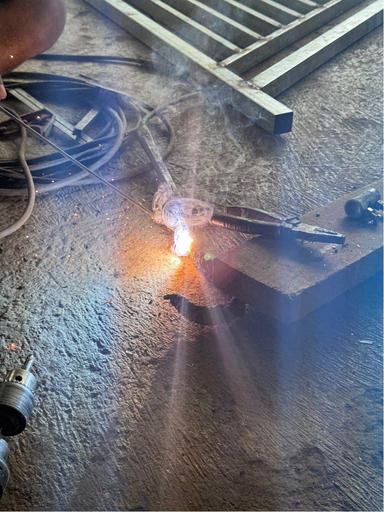Small fire or welding spark on a concrete floor near coiled cables and a metal ladder brace