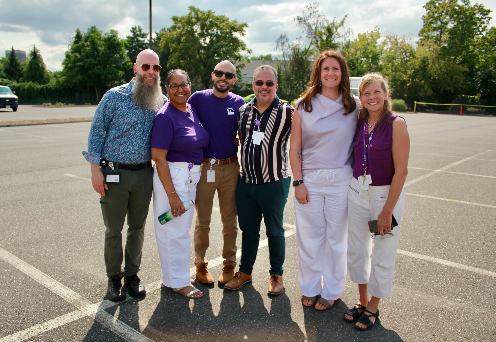 6 of BHN's staff members smile for a photo in a parking lot.