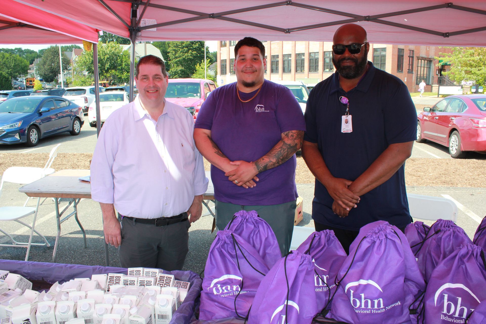 3 men of BHN's culinary team smile and pose for a photo in behind the food and water that was shared at BHN's International Overdose Awareness Day event.