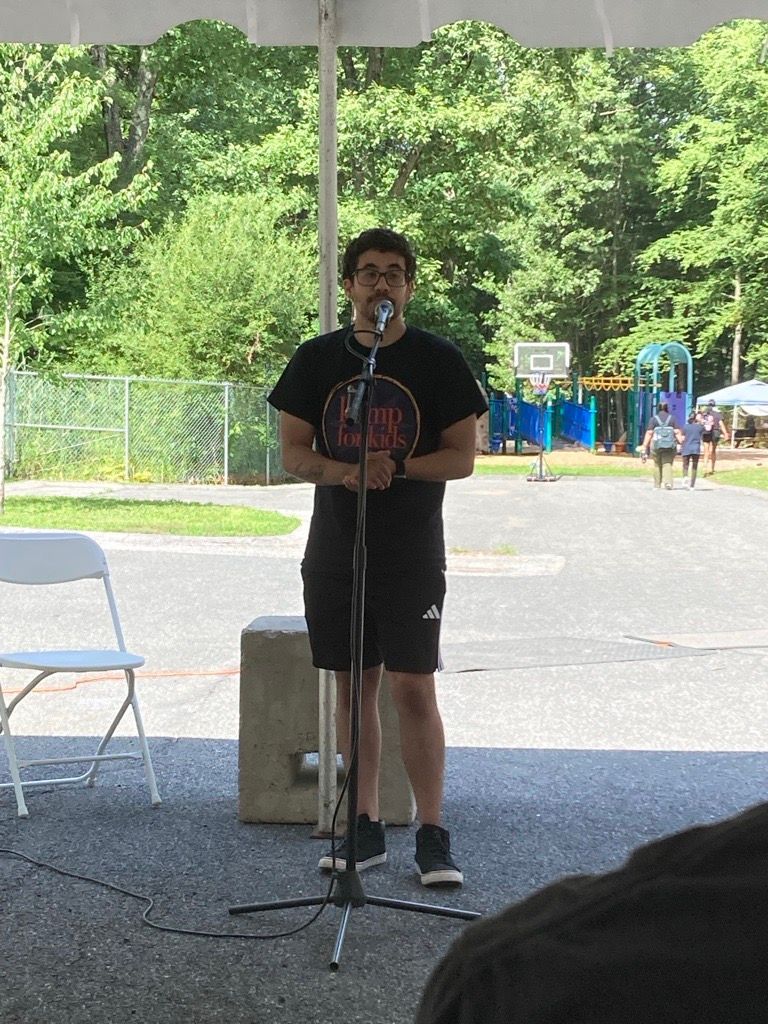 A Kamp counselor delivers a speech at the Kamp for Kids opening day event.