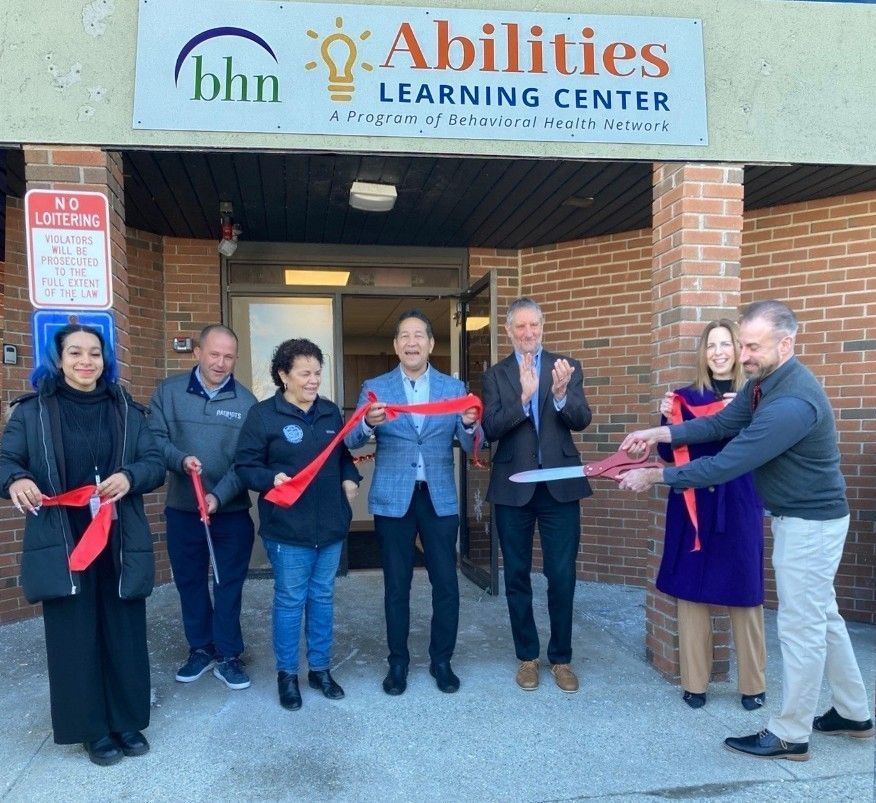 Program staff and local officials cutting the ribbon at the grand opening celebration.