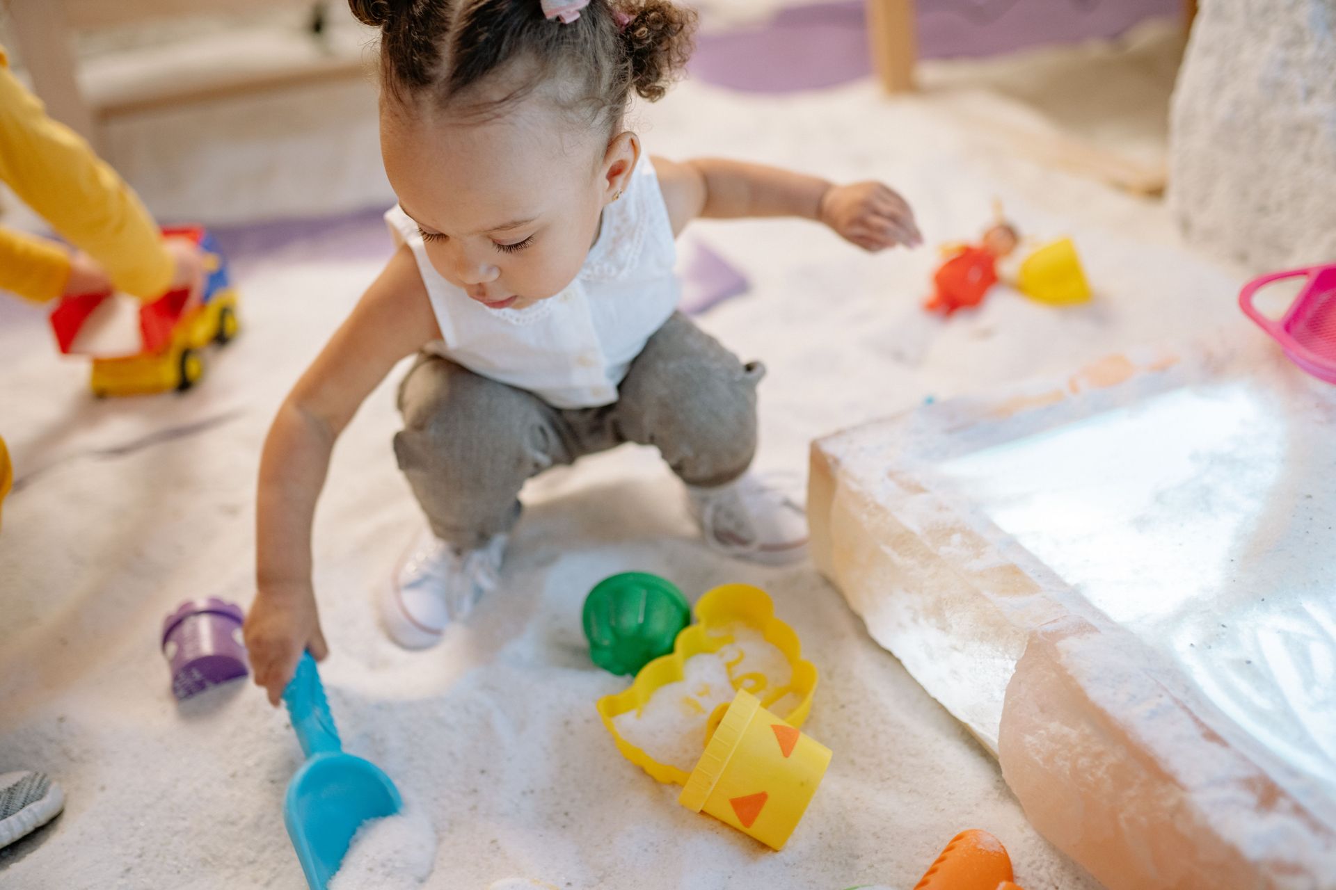 a toddler playing in a sandbox