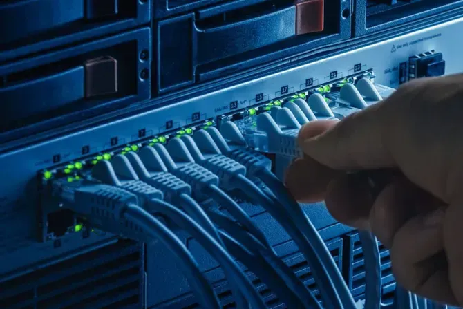 Person Connecting a Network Cable — Communication Systems in Belmont North, NSW