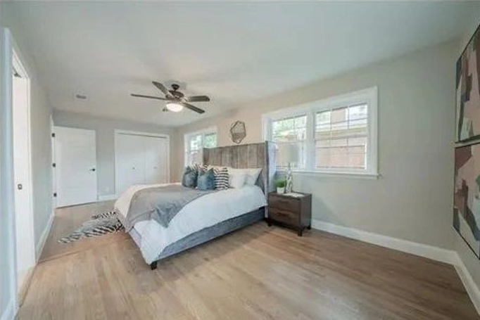 A bedroom with a large bed and a ceiling fan.