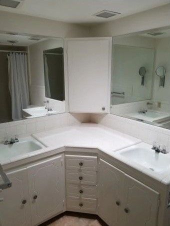 A bathroom with two sinks and a large mirror.
