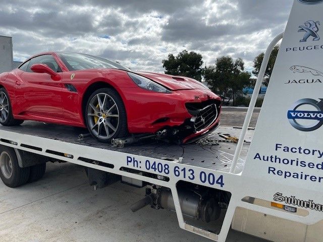 A Tow Truck Is Towing A Damaged Car On The Side Of The Road — Lorne Accident & Assist Towing In Eastern View, VIC