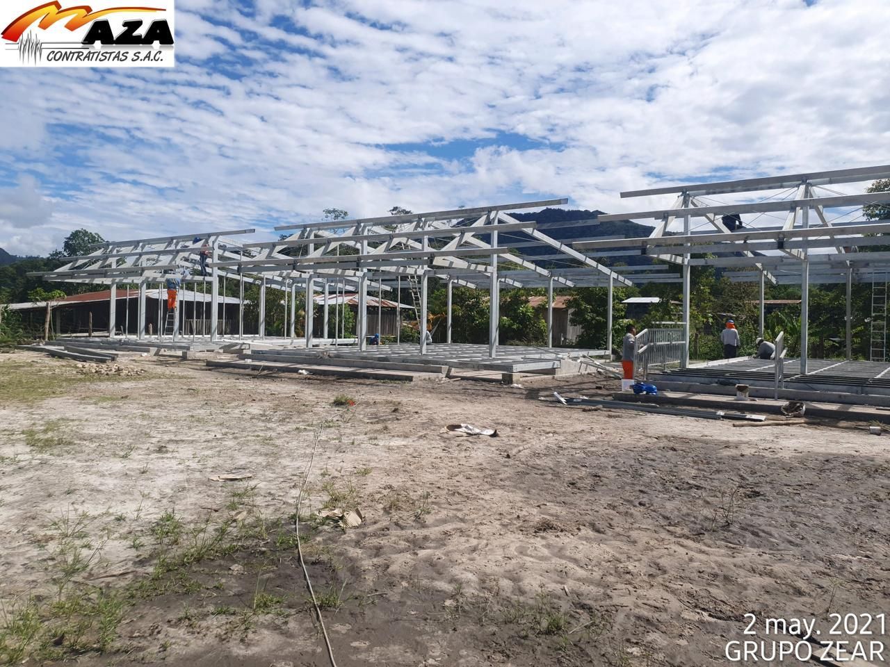 Estructura de acero parcialmente construida en un terreno arenoso bajo un cielo nublado