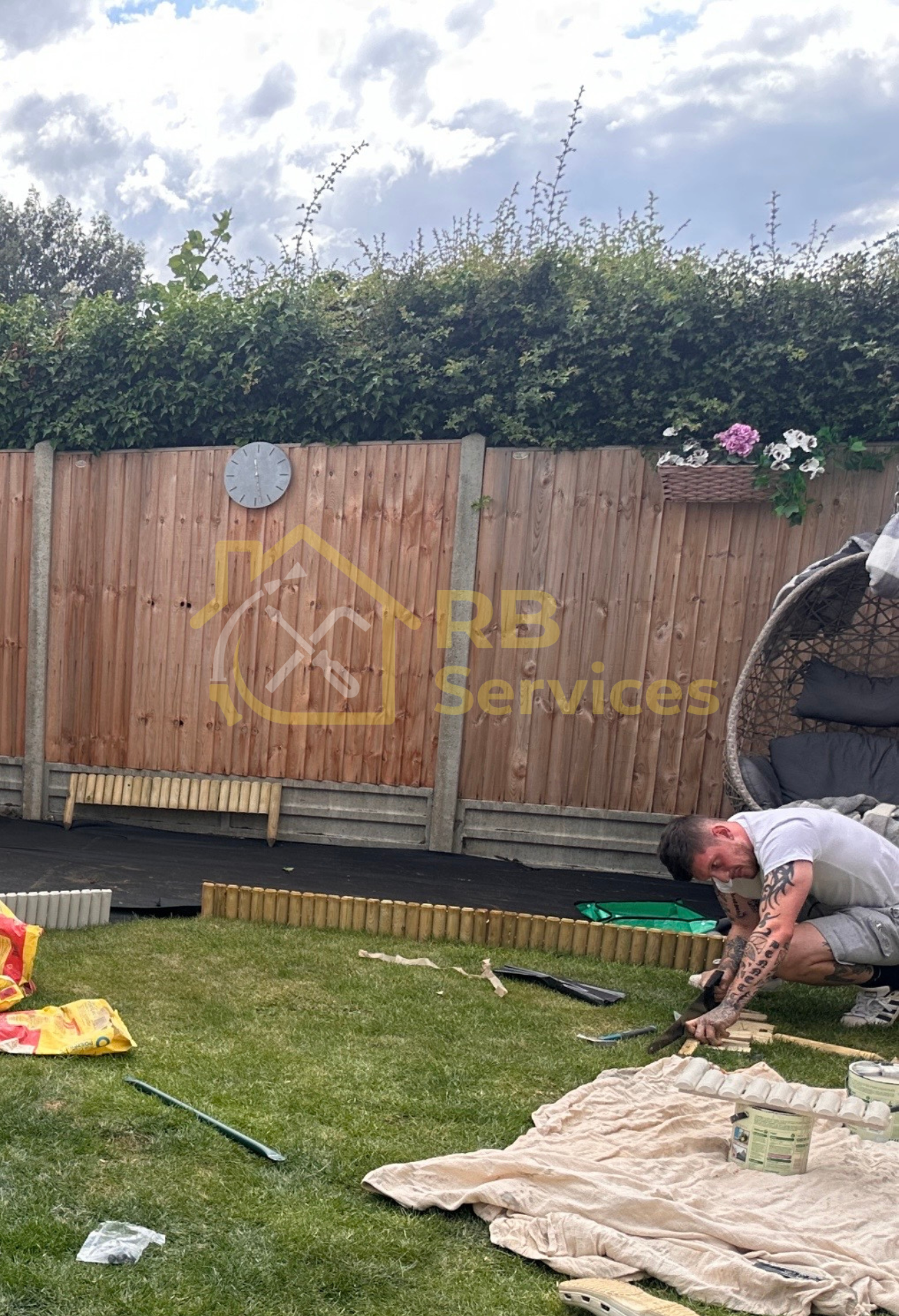 Wooden border fitted and painted for a children's play area in the garden assembly St Albans
