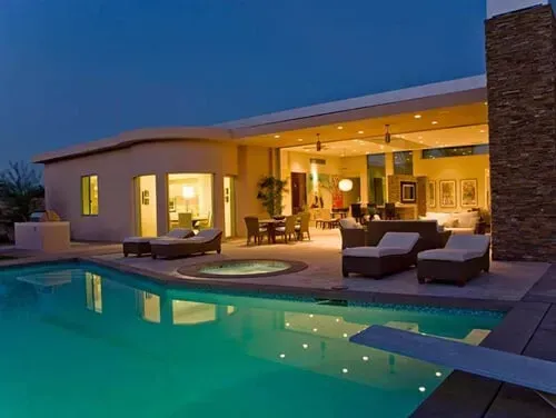 A house with a large swimming pool in front of it