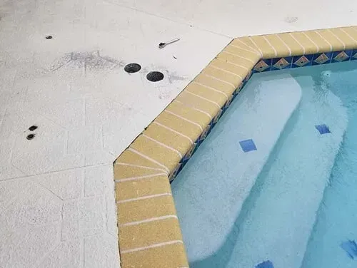 A swimming pool with stairs and a white tile floor.