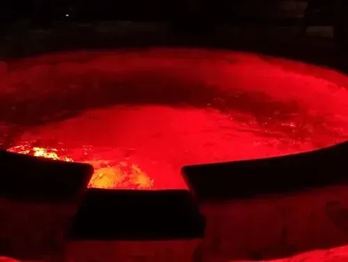 A hot tub is lit up with red lights at night.