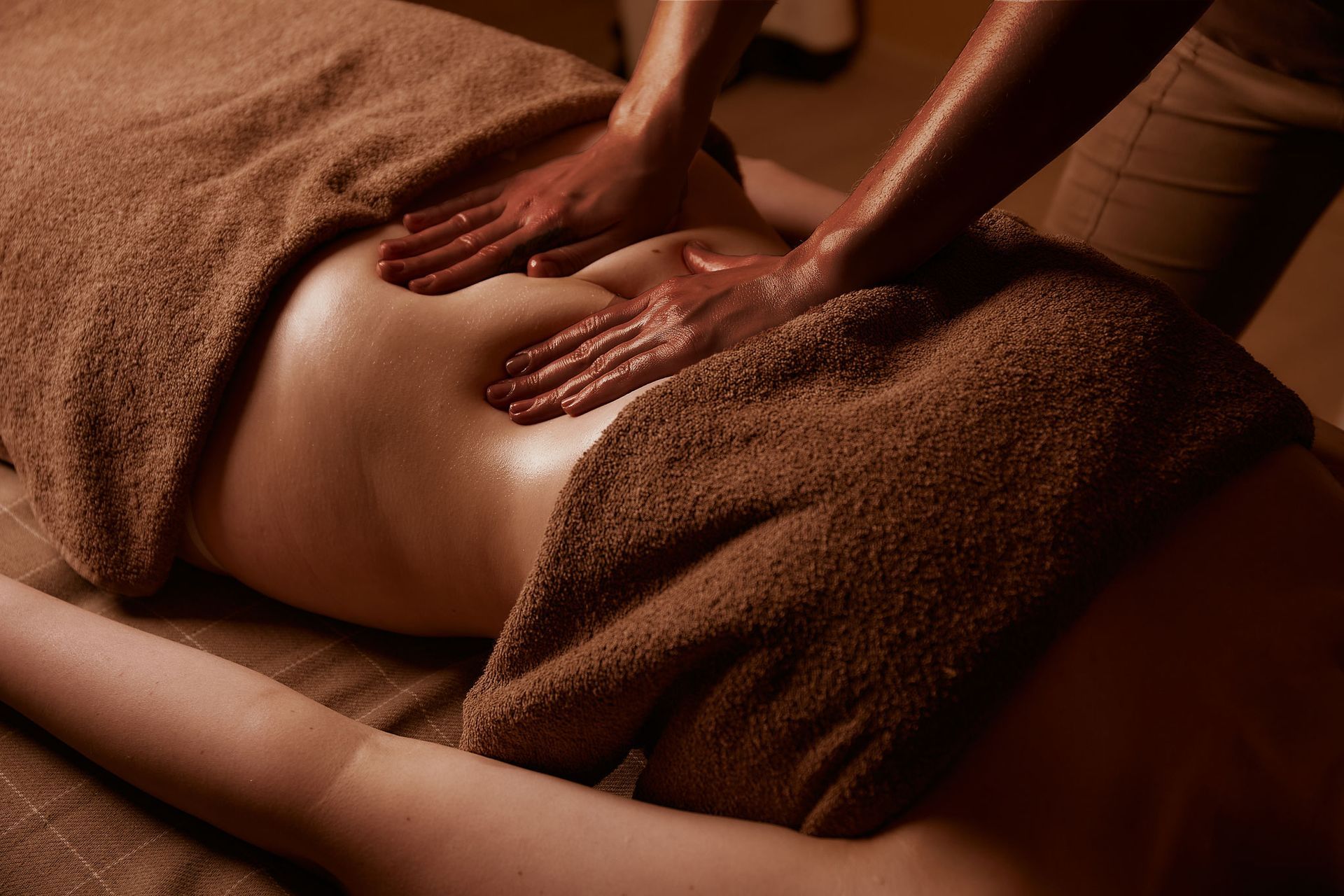 A woman is laying on a bed getting a lymphatic massage