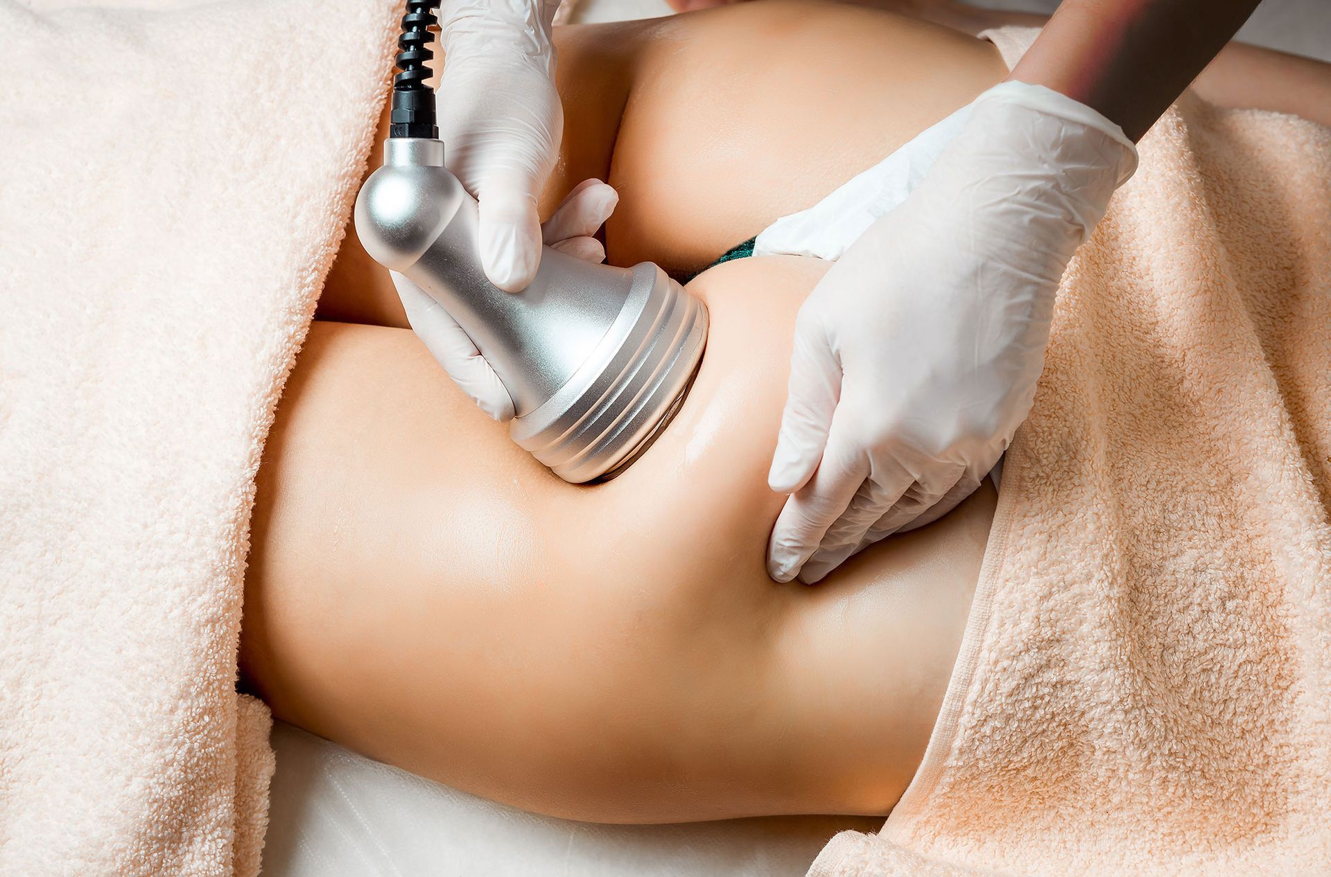 A woman is getting body sculpting treatment on her leg