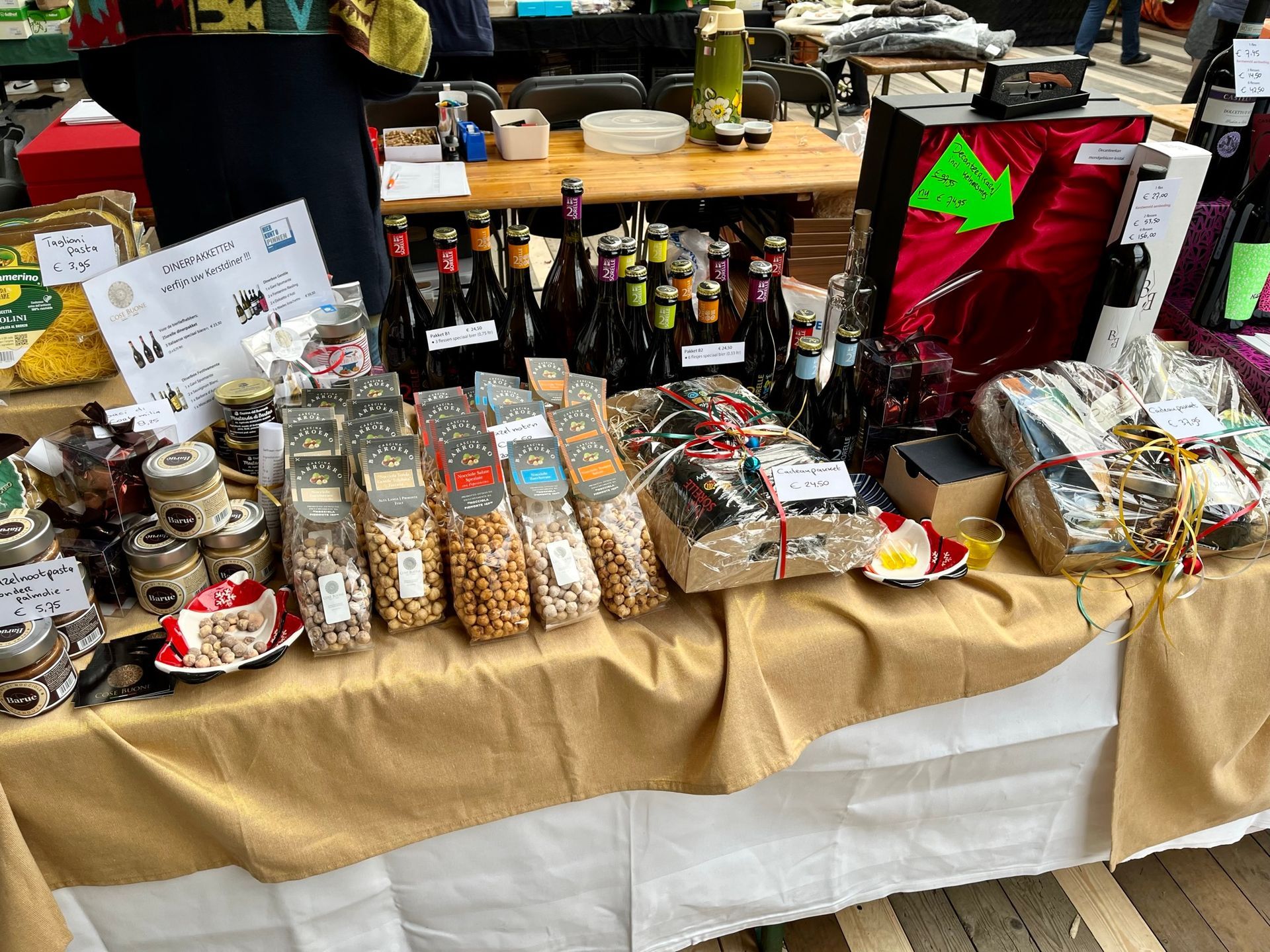 Marktkraam met diverse voedingsmiddelen zoals noten, potten en flessen met dranken.