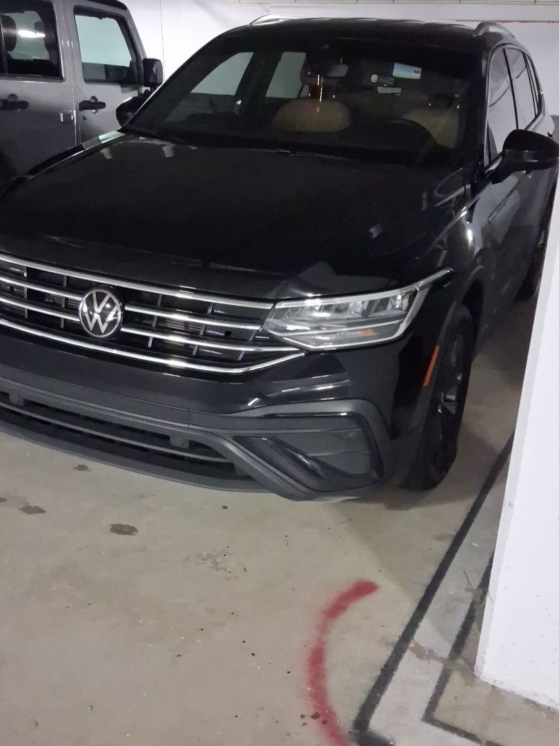 Black Volkswagen SUV parked in an indoor garage, front view.