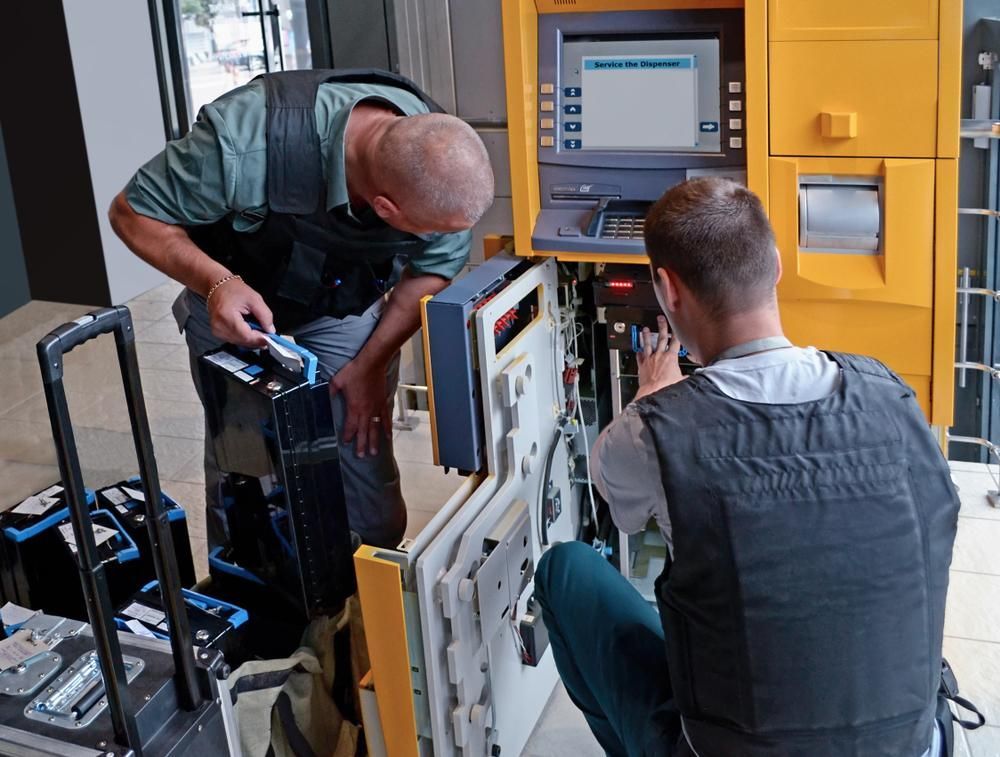 Two Men Are Working on A Yellow Atm Machine — Stellar Test and Tag in Gunnedah, NSW
