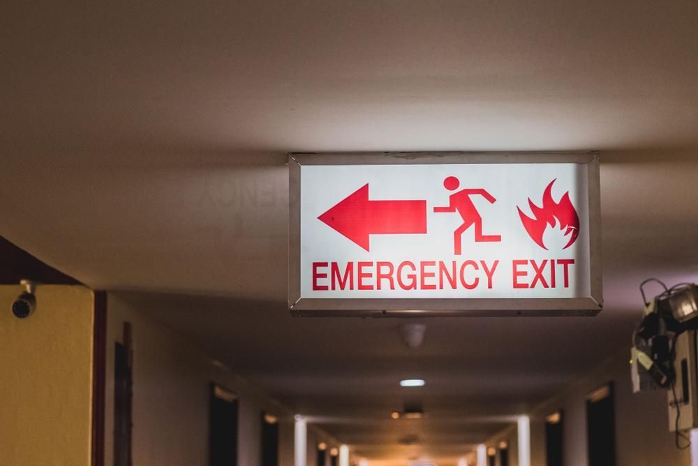 An Emergency Exit Sign Is Hanging from The Ceiling of A Hallway — Stellar Test and Tag in Gunnedah, NSW