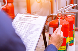 Person Inspecting Fire Extinguishers With A Clipboard — Stellar Test and Tag in Gunnedah, NSW