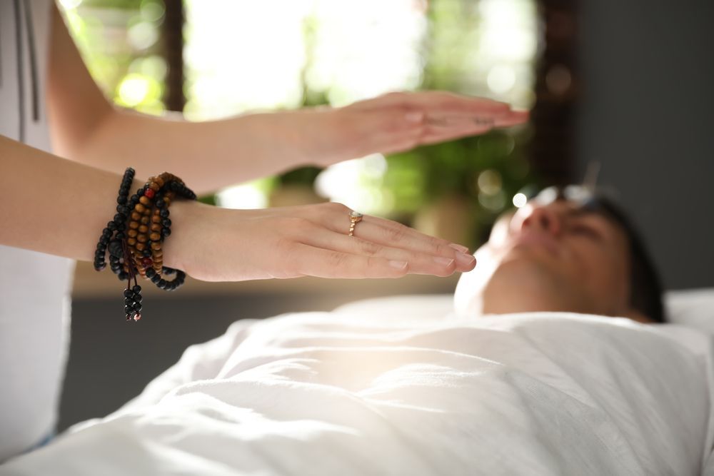 A Man is Laying on a Bed Getting a Healing Treatment From a Woman — Angel of Light Nick Turner In East Lismore, NSW