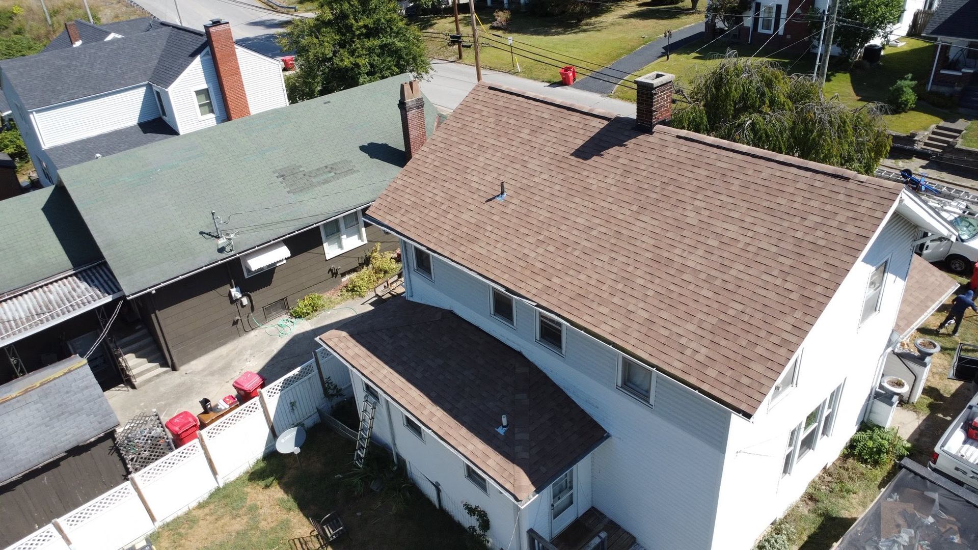 Aerial view of two houses with tiled roofs and a courtyard in a residential area