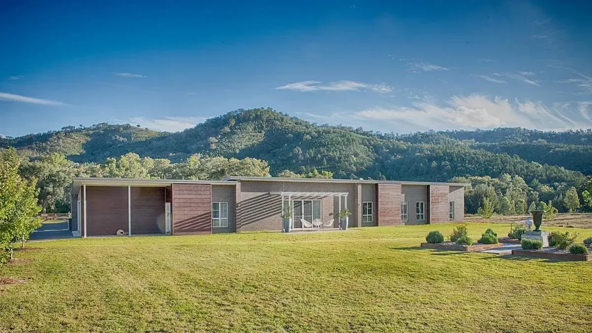 Long, Modern Building on a Grassy Plain With Mountain Range in the Background — D&C Projects in Tamworth, NSW