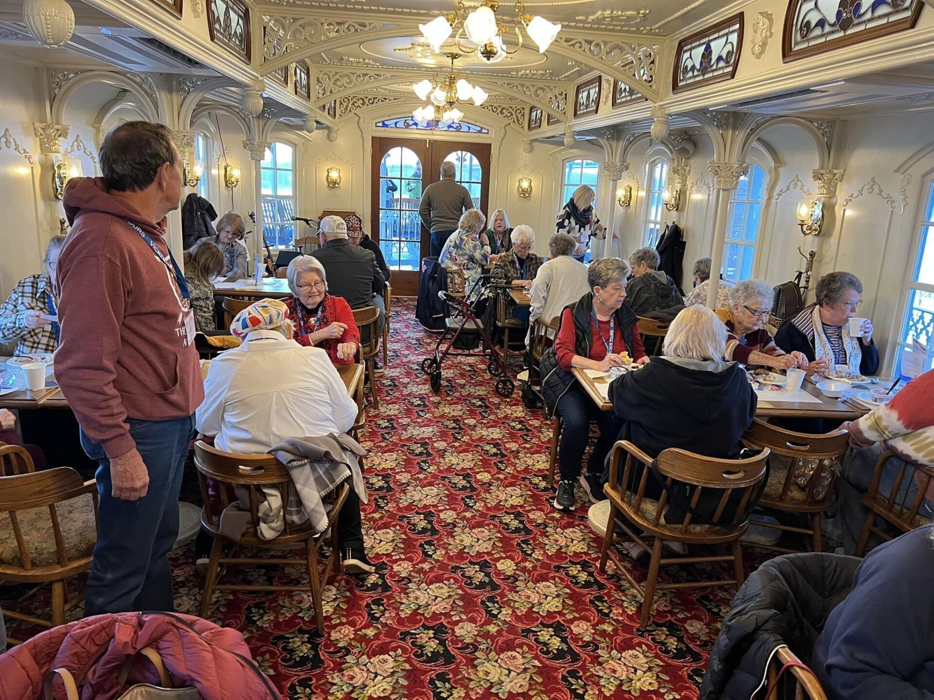 a group of people are sitting at tables in a restaurant .