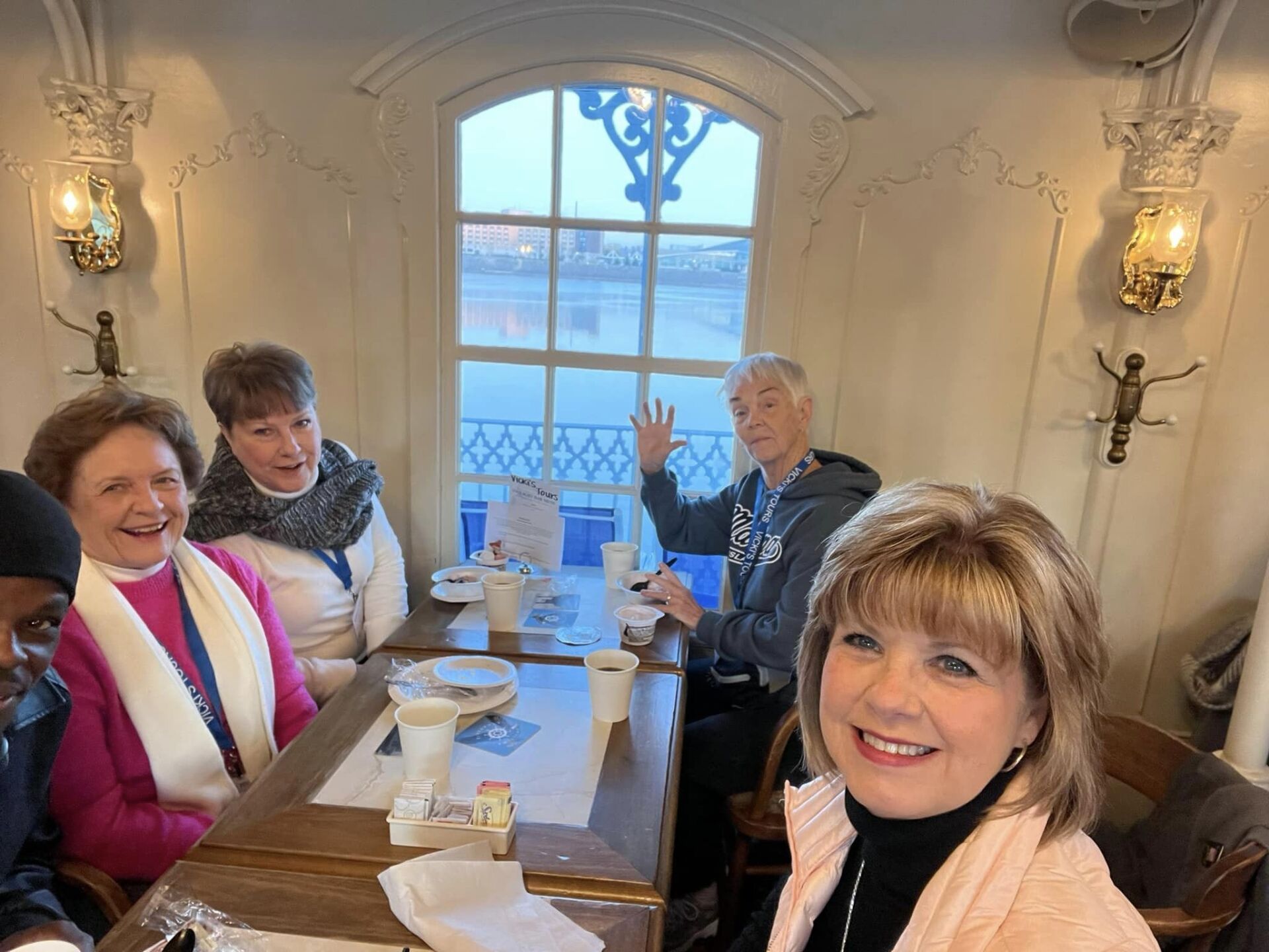 a group of people are sitting at a table in front of a window .