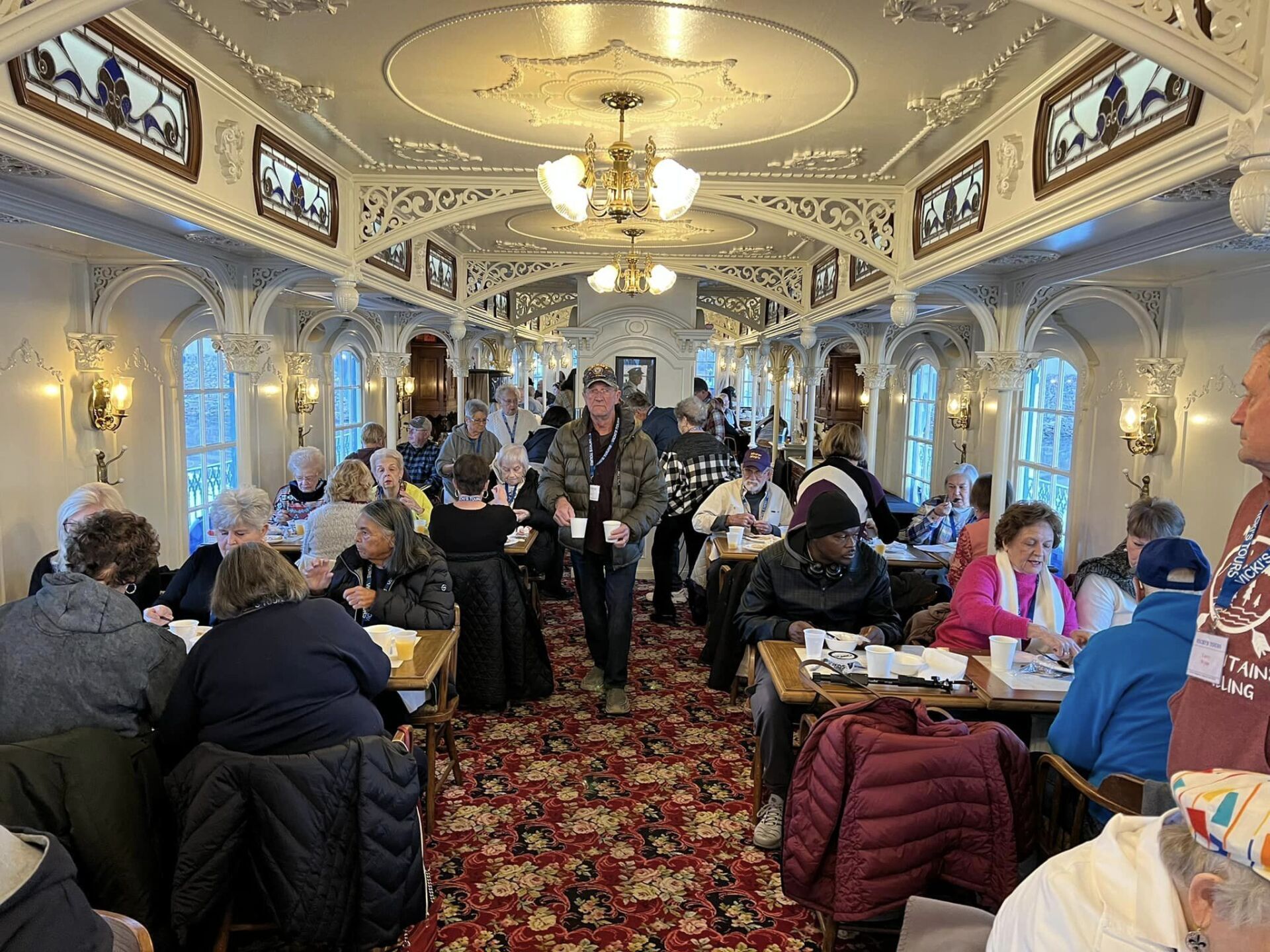 a group of people are sitting at tables in a large room .