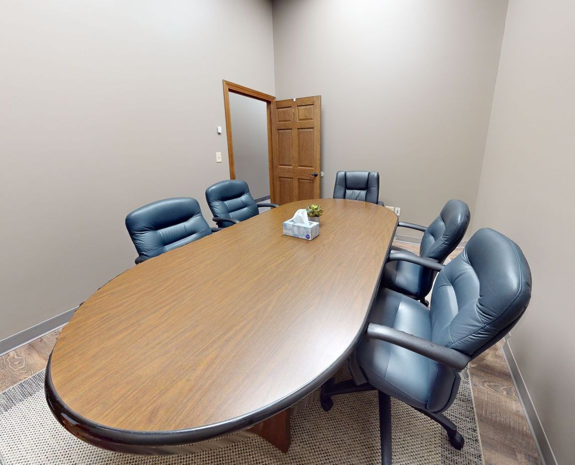 A conference room with a long table and chairs.
