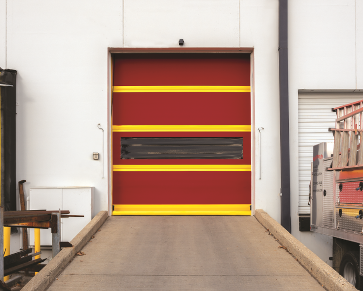 A red door with yellow stripes is open in a warehouse