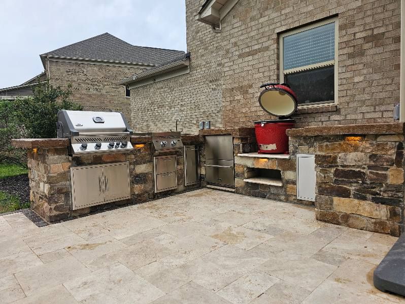 Outdoor kitchen with grill, smoker, and storage built into stone structure.