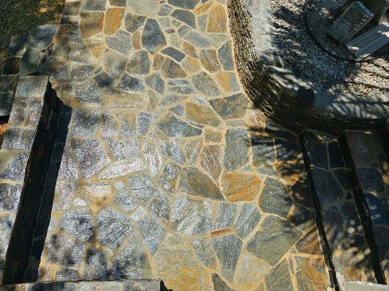 Stone pathway with irregular-shaped tiles, various shades of gray, gold and tan.