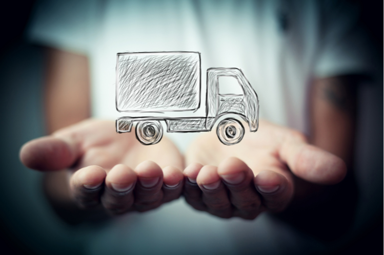 A person is holding a drawing of a delivery truck in their hands.