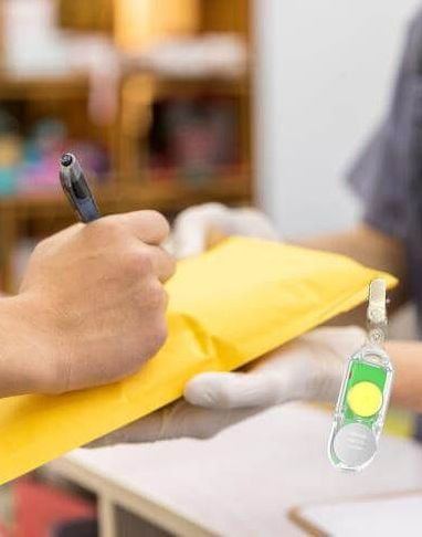 A person is writing on a piece of paper with L102 Chargeable Wireless Light Tag